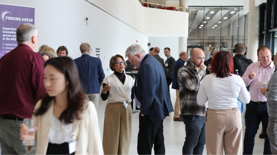 A group of people networking in a brightly lit hall.